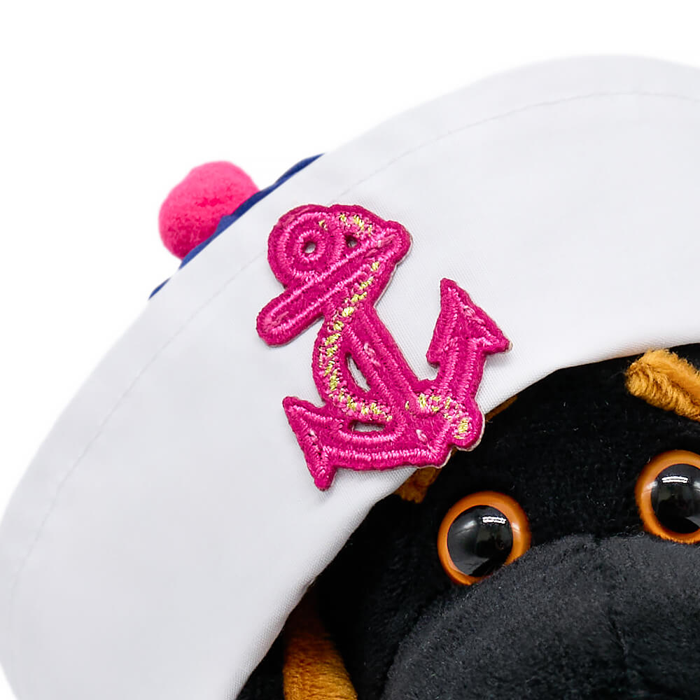 in a striped overalls and a panama hat with an anchor