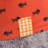 in orange fish-dotted t-shirt with a lion