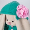 in an emerald coat with a pink flower